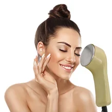 Young woman using face massager